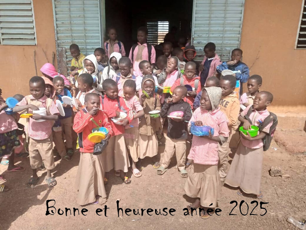 Les vœux 2025 : les enfants de l'un des villages de la région de Koudougou prennent un repas devant leur salle de classe.